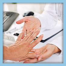doctor examining elderly hands for signs of arthritis