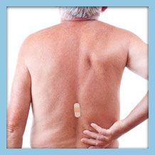 Elderly male patient with a visible bandaid on his spine, indicating recent spinal surgery